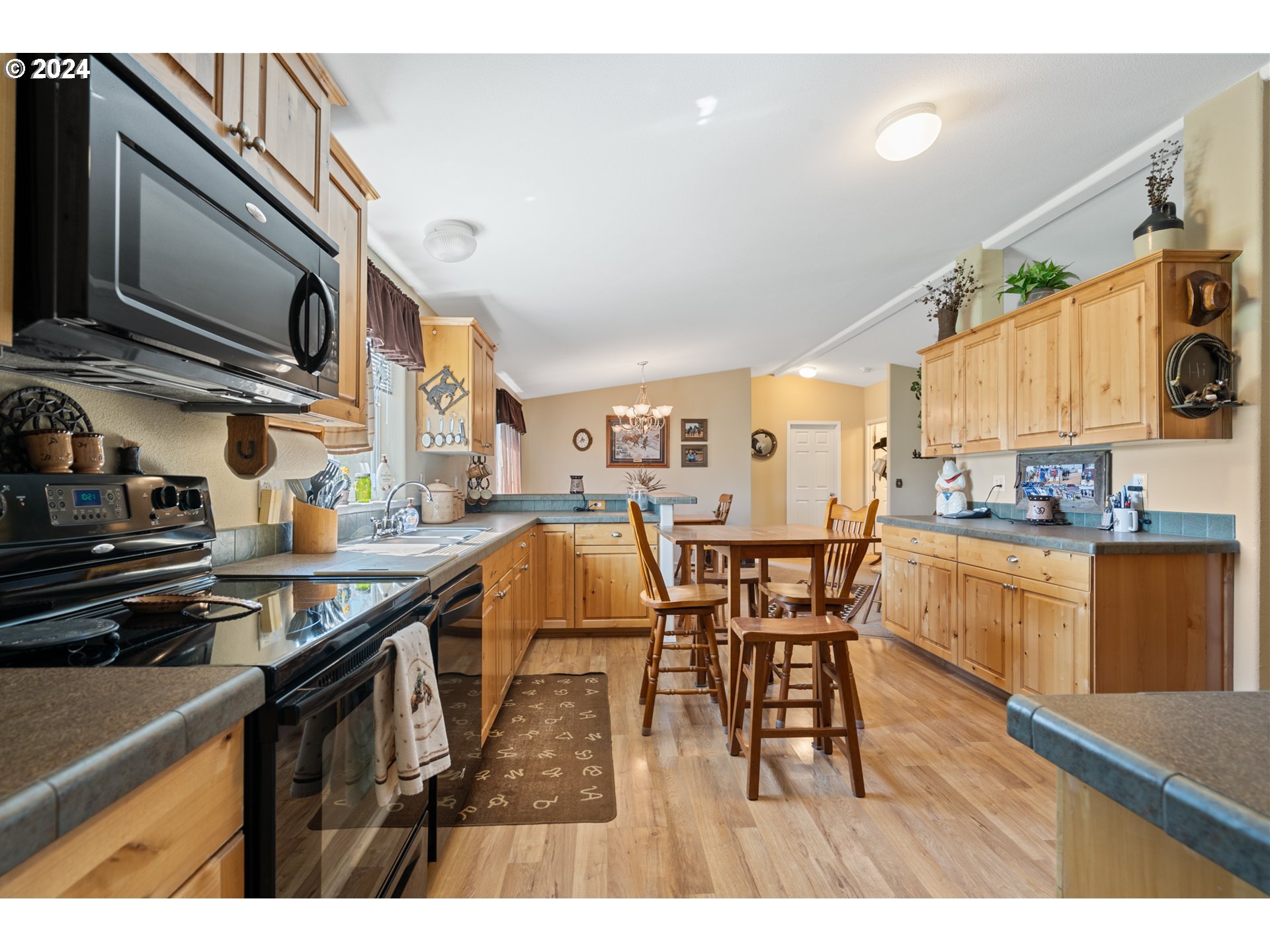 81385 North Golda Road Hermiston, OR 97838 - Photo 6 of 40 a open kitchen with stainless steel appliances granite countertop a kitchen island a stove a sink a dining table and chairs