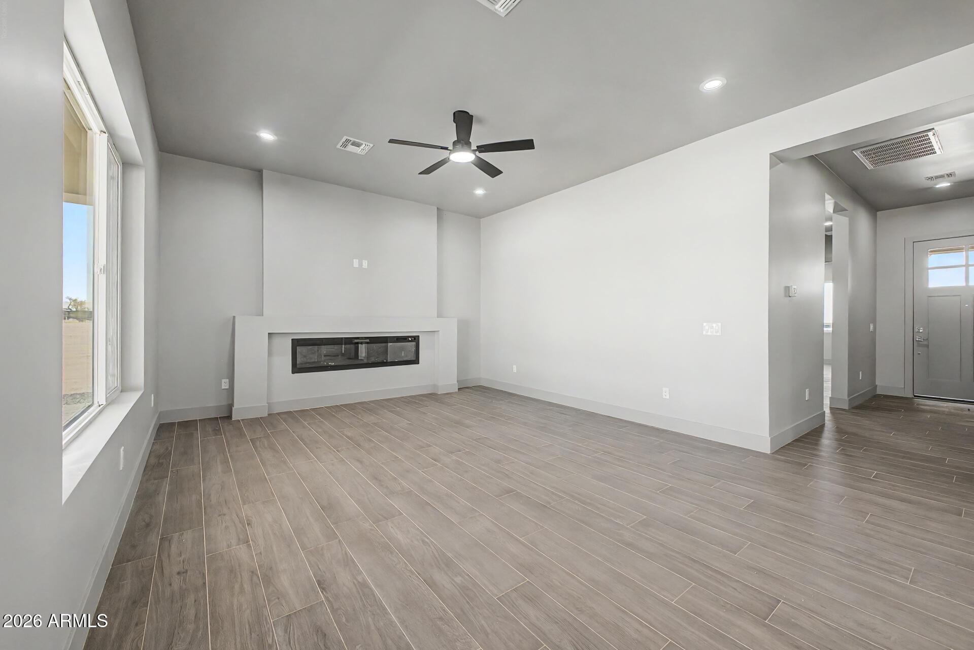 40461 West Robles Road Stanfield, AZ 85172 - Photo 22 of 54 an empty room with wooden floor ceiling fan and windows