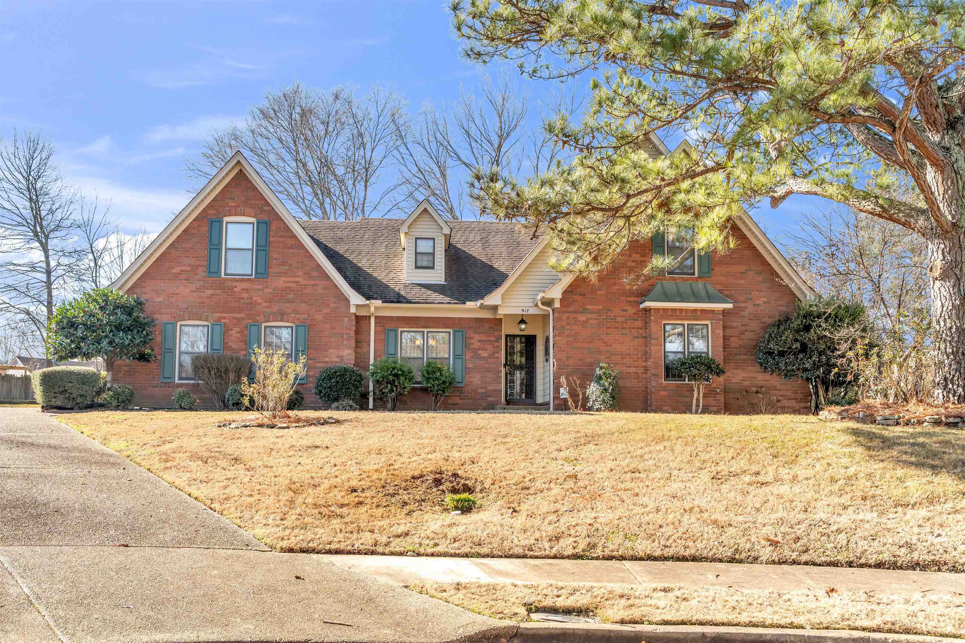 View of front facade featuring brick siding, a front lawn, and a shingled roof