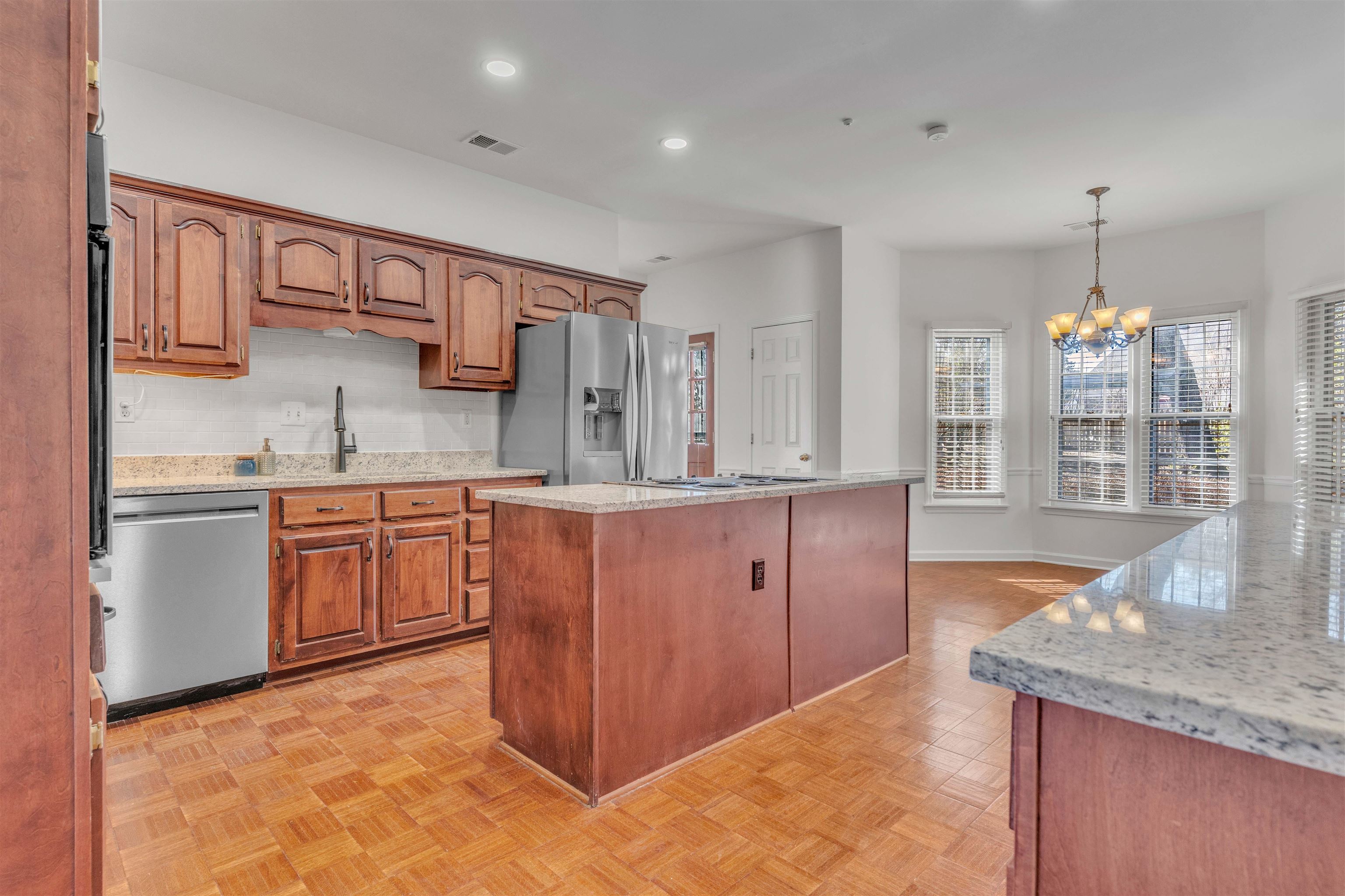 917 Valleyview Lane Collierville, TN 38017 - Photo 24 of 35 Kitchen featuring light stone counters, wood finish cabinetry, stainless steel appliances, and a kitchen island