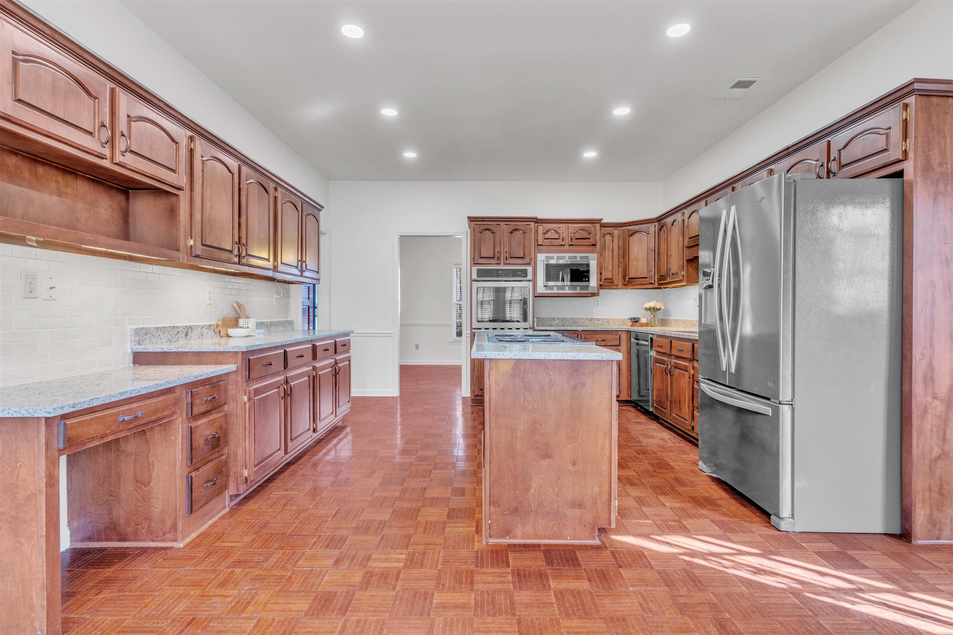 917 Valleyview Lane Collierville, TN 38017 - Photo 27 of 35 Kitchen with a center island, stainless steel appliances, light stone counters, wood finish cabinetry, and recessed lighting