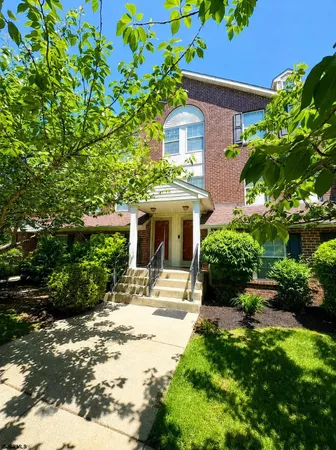 a front view of a house with a yard and potted plants