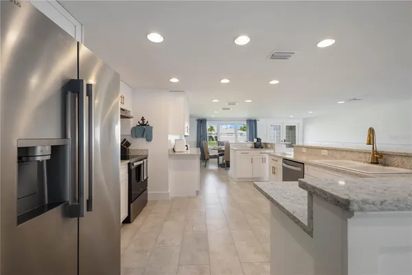 a kitchen with a sink white cabinets and stainless steel appliances