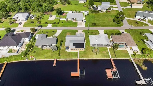 an aerial view of residential houses with outdoor space and parking