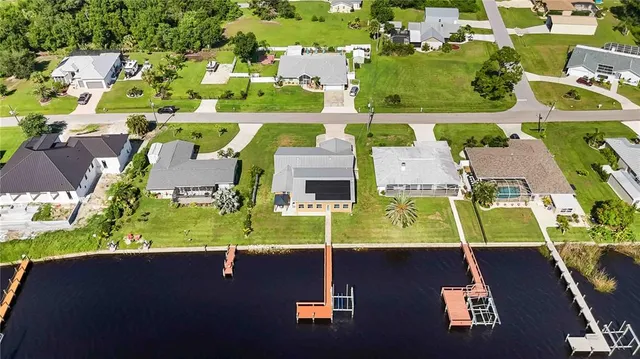 an aerial view of residential houses with outdoor space and parking