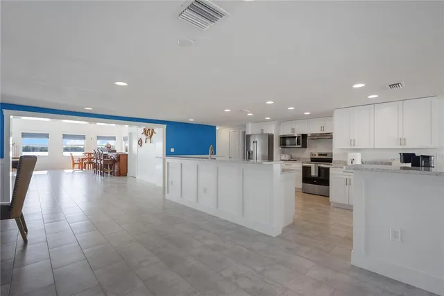 a view of a kitchen with kitchen island and stainless steel appliances