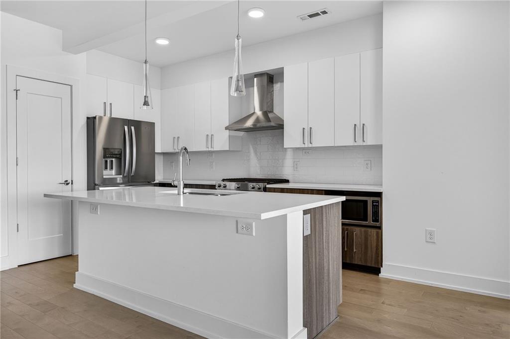 775 Juniper Street Northeast, Unit 413 Atlanta, GA 30308 - Photo 11 of 47 a kitchen with stainless steel appliances granite countertop a sink stove and refrigerator