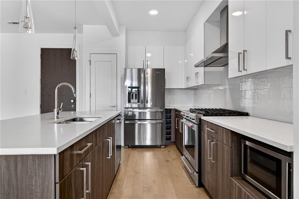 775 Juniper Street Northeast, Unit 413 Atlanta, GA 30308 - Photo 12 of 47 a kitchen with stainless steel appliances granite countertop a sink stove and refrigerator