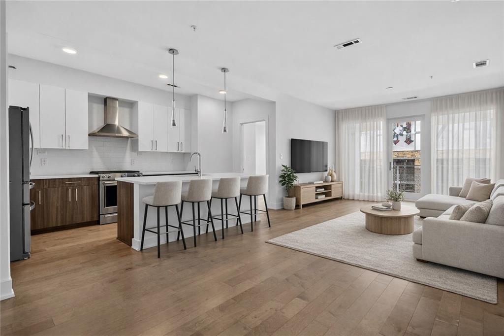 775 Juniper Street Northeast, Unit 413 Atlanta, GA 30308 - Photo 2 of 47 a living room with furniture and a flat screen tv
