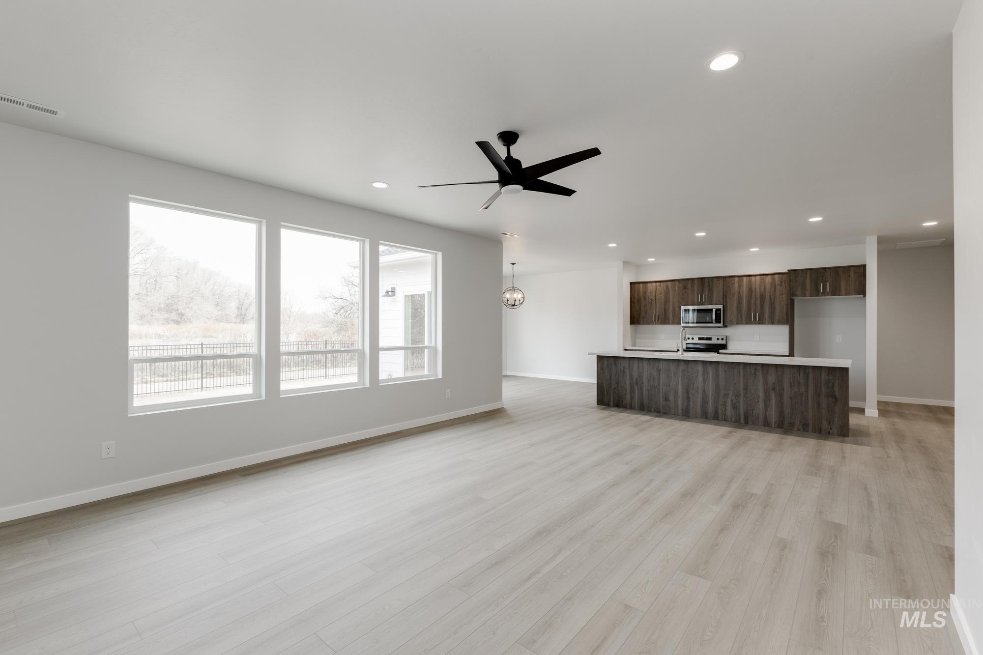 13638 Redway Court Caldwell, ID 83607 - Photo 11 of 21 Unfurnished living room featuring a ceiling fan, light wood-type flooring, recessed lighting, and a chandelier