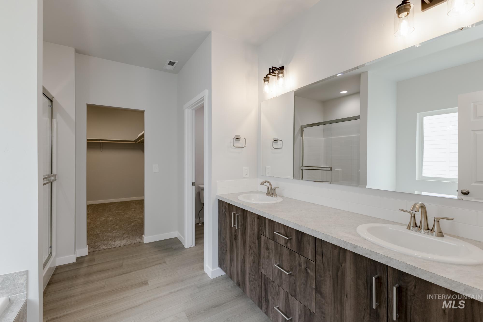 13638 Redway Court Caldwell, ID 83607 - Photo 19 of 21 Full bathroom with a spacious closet, a stall shower, double vanity, and light wood-style flooring