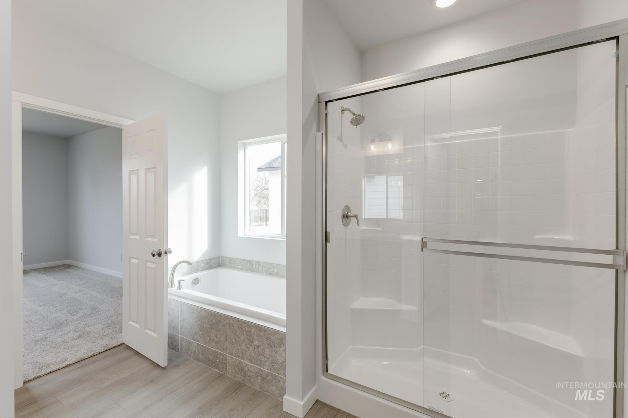 13638 Redway Court Caldwell, ID 83607 - Photo 20 of 21 Bathroom with a stall shower, light wood-style floors, and a bath