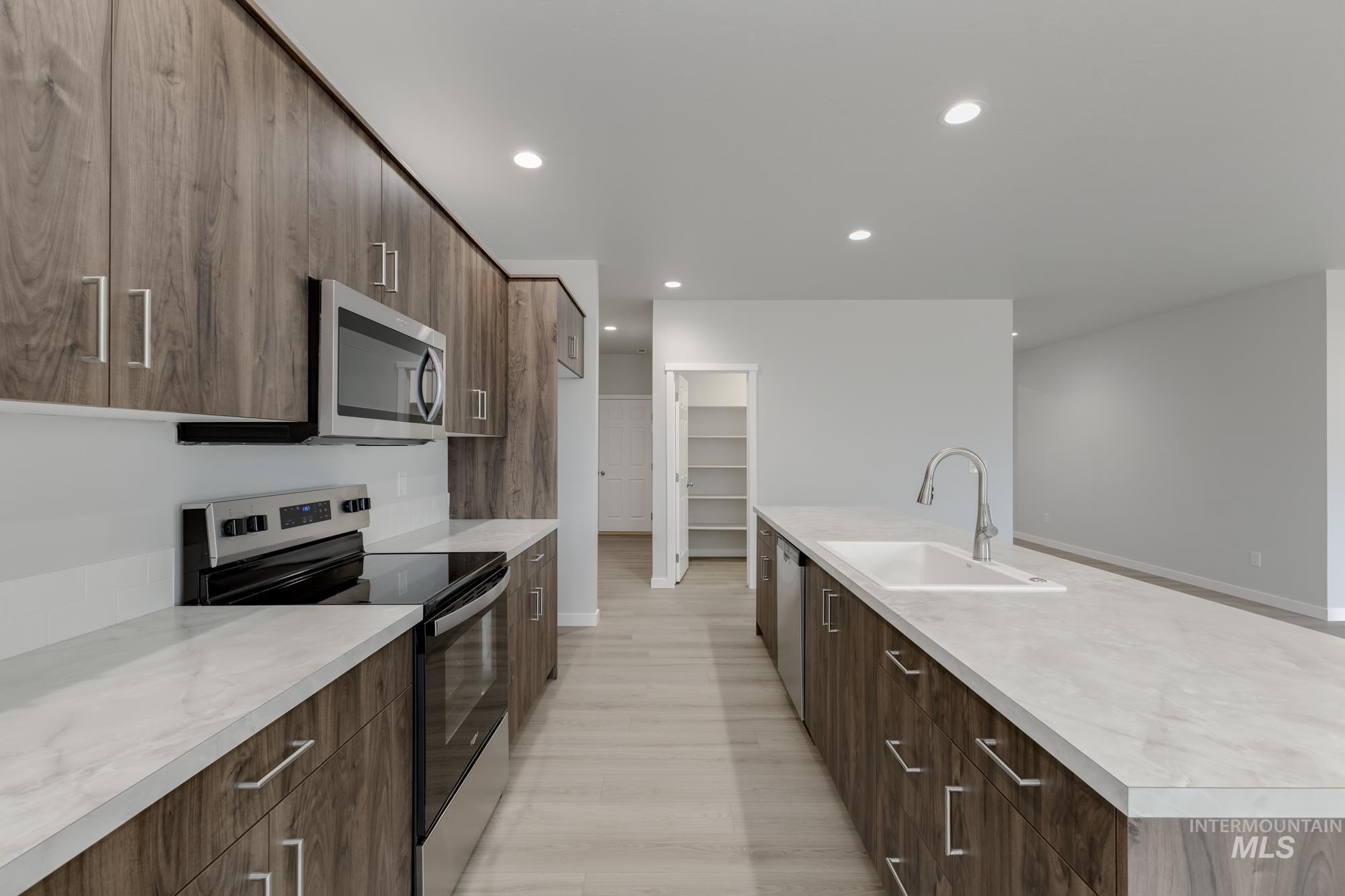 13638 Redway Court Caldwell, ID 83607 - Photo 6 of 21 Kitchen with stainless steel appliances, modern cabinets, a large island with sink, recessed lighting, and light wood-style floors