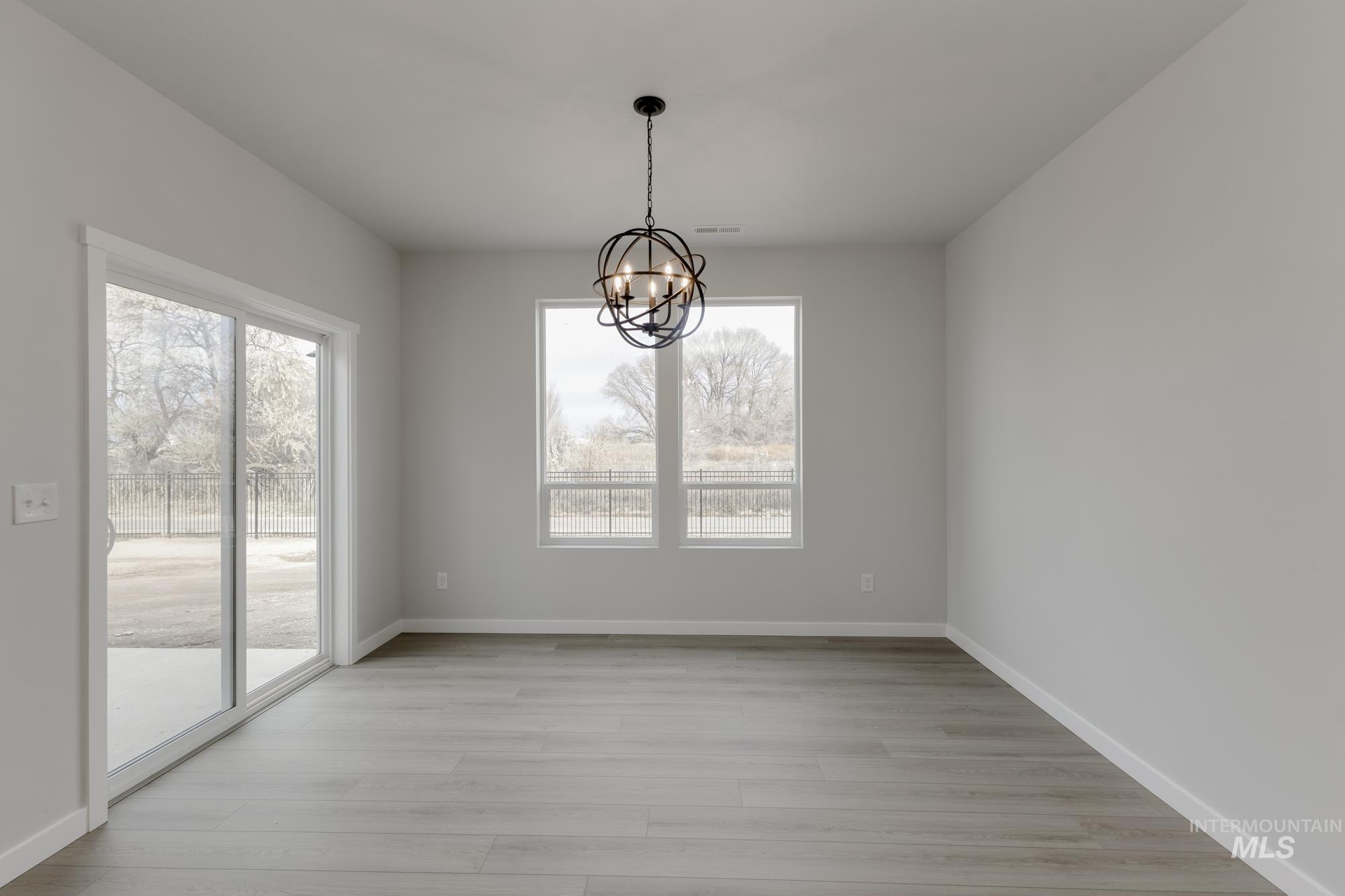13638 Redway Court Caldwell, ID 83607 - Photo 8 of 21 Unfurnished dining area featuring a chandelier and light wood-type flooring