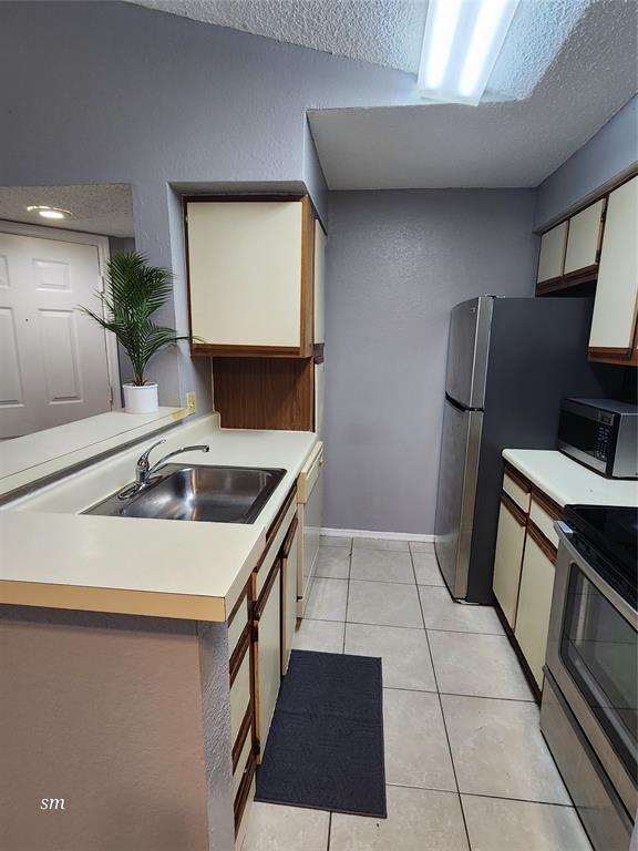 2866 South University Drive, Unit 5308 Davie, FL 33328 - Photo 5 of 26 a kitchen with a sink a stove and a microwave