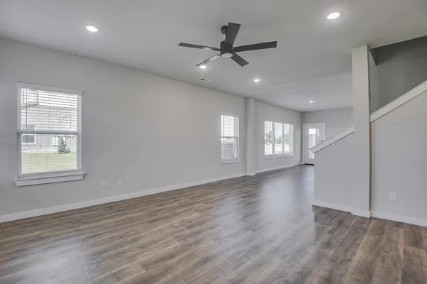 a view of an empty room with a window and wooden floor