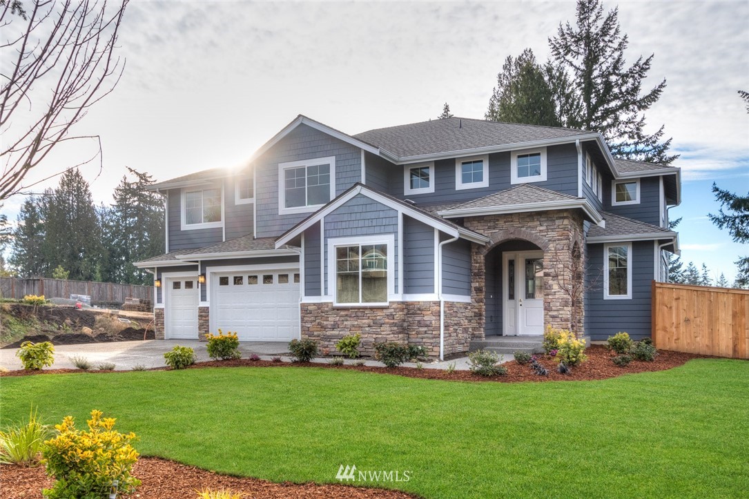 a front view of a house with a garden and yard