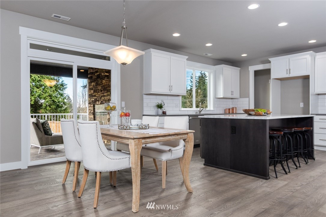 6505 Southeast 2nd Place Renton, WA 98059 - Photo 10 of 25 a kitchen with kitchen island granite countertop a table chairs sink and cabinets