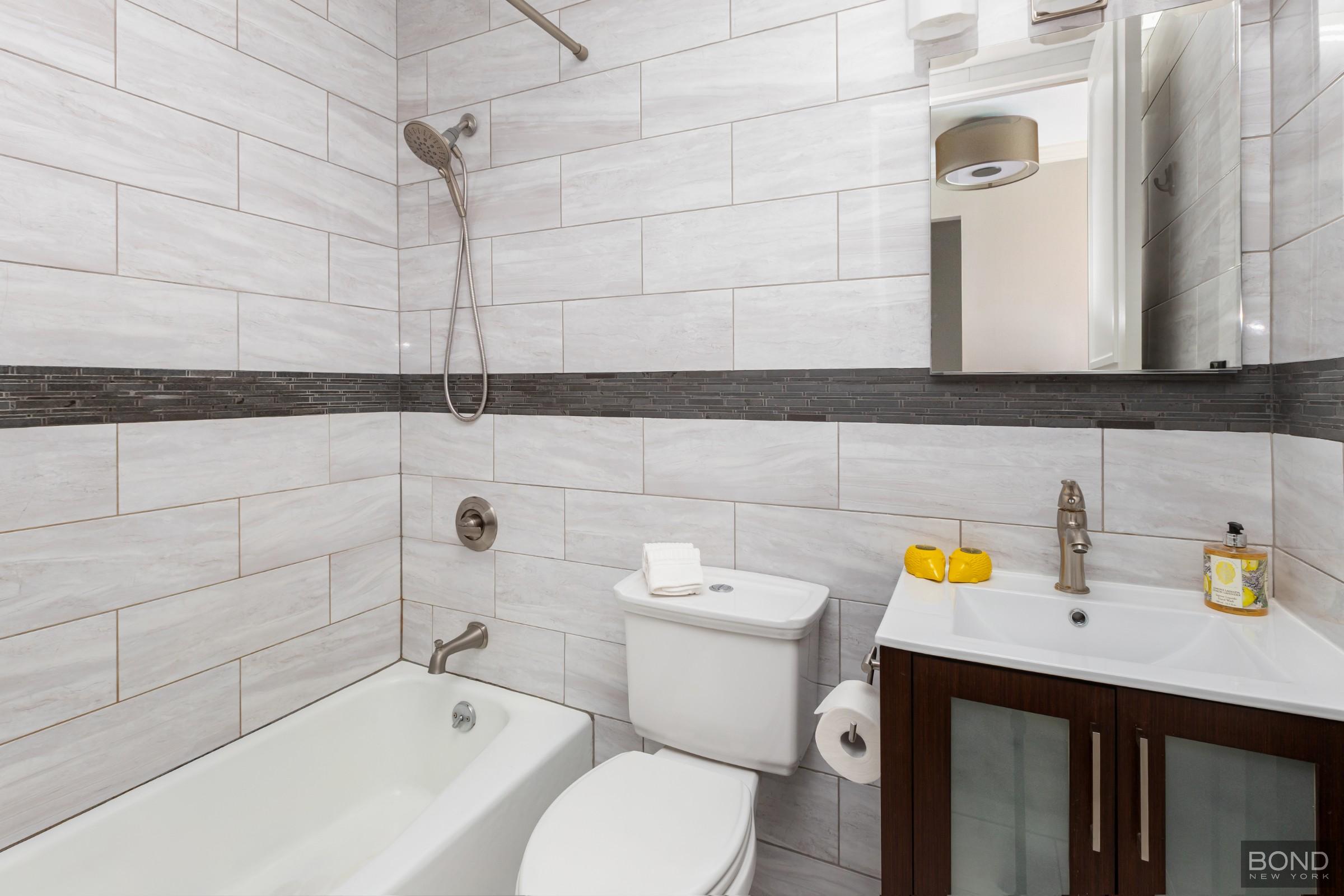393 West 49th Street, Unit 3OO Manhattan, NY 10019 - Photo 8 of 16 a bathroom with a sink and a bathtub