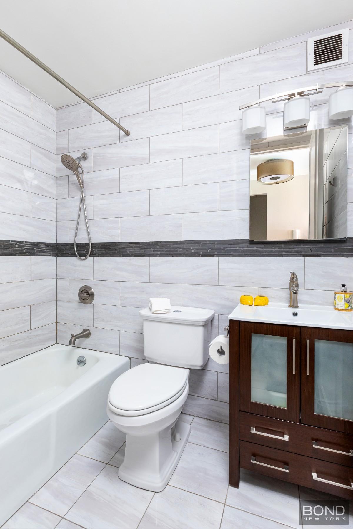 393 West 49th Street, Unit 3OO Manhattan, NY 10019 - Photo 9 of 16 a bathroom with a sink a toilet and bathtub