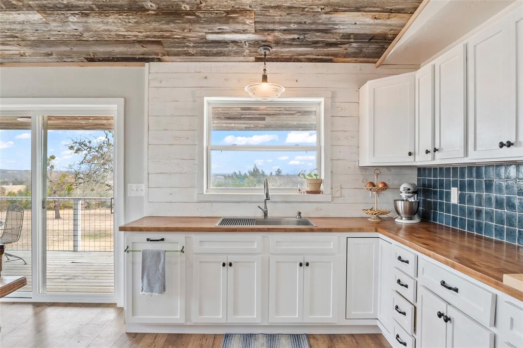 7949 North Fm 373 Road Muenster, TX 76252 - Photo 22 of 38 a kitchen with granite countertop a sink window and cabinets