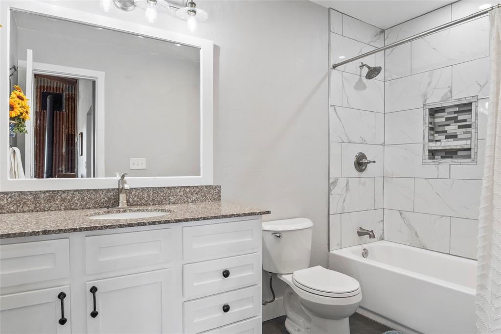 7949 North Fm 373 Road Muenster, TX 76252 - Photo 26 of 38 a bathroom with a granite countertop toilet a sink and bathtub
