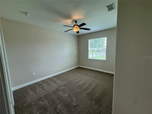 an empty room with closet and fan