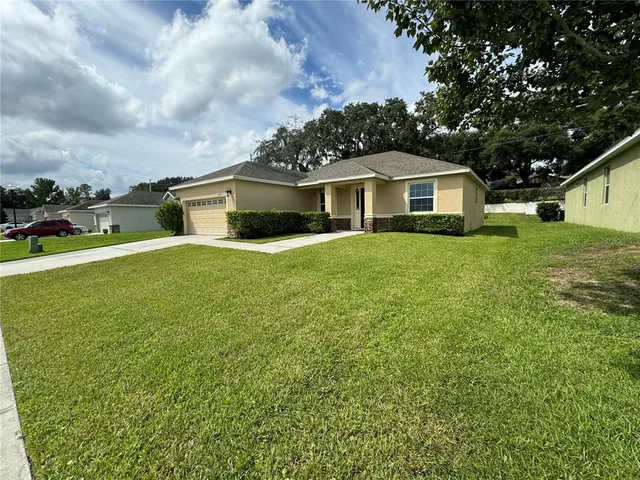 a front view of a house with yard and green space