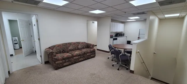 a living room with furniture and a fan