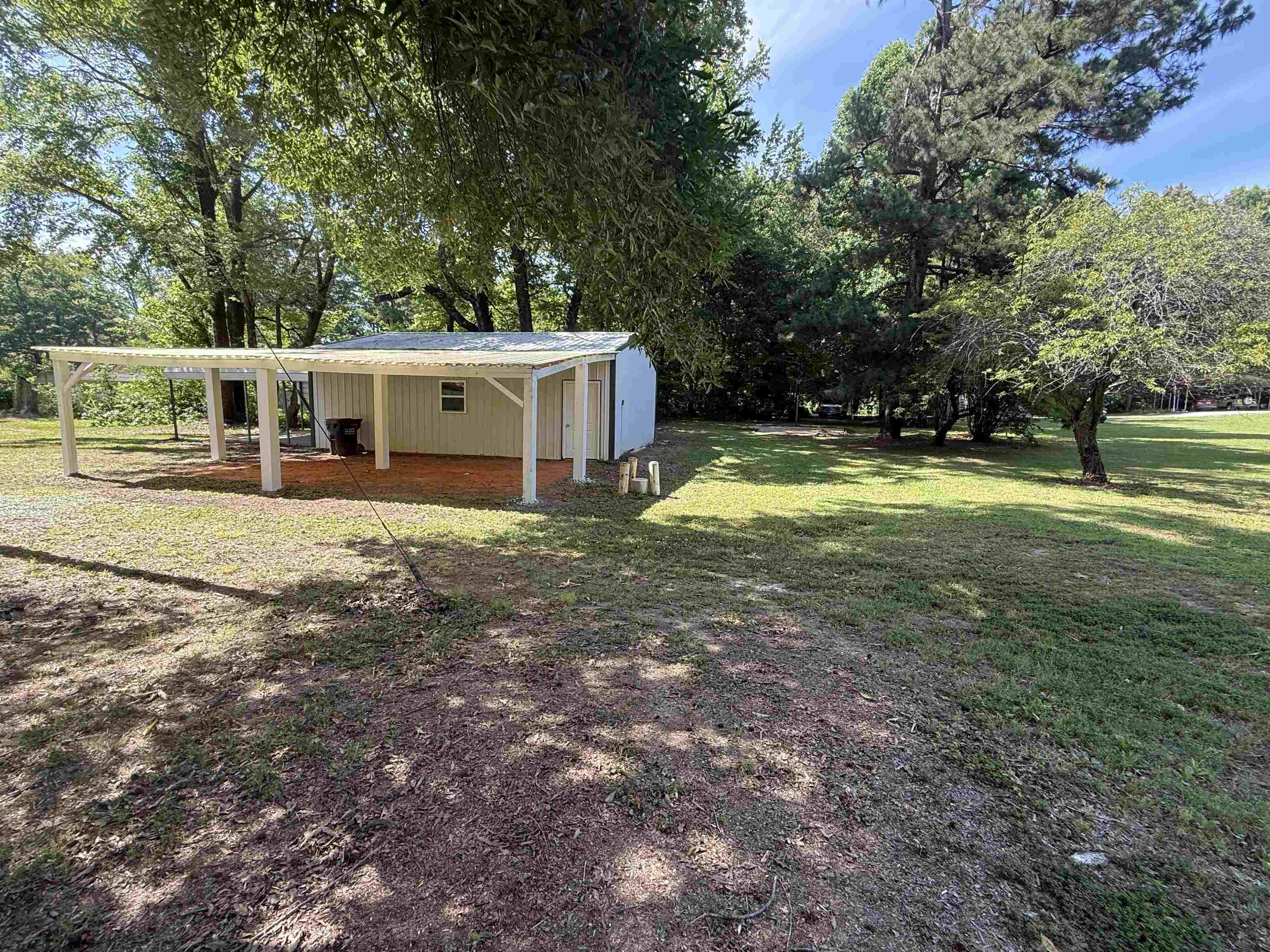 195 Poole Road Moscow, TN 38057 - Photo 18 of 21 Detached outbuilding featuring a white paneled exterior, covered patio area with exposed rafters, and a side entry door