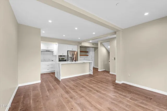 a view of kitchen with kitchen island white cabinets and refrigerator