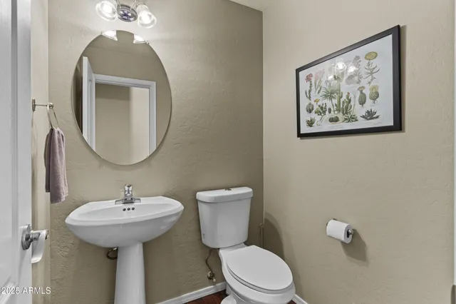 a bathroom with a toilet a sink and mirror