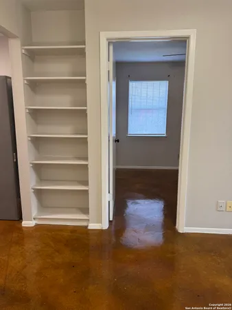 a view of an empty room with a fireplace and a window