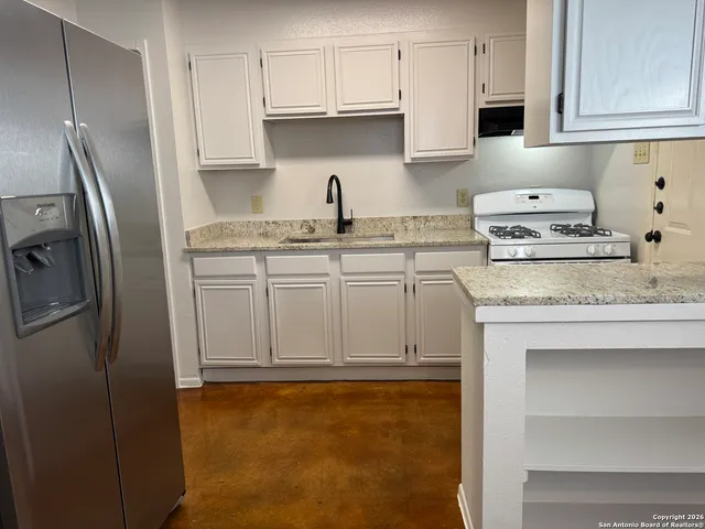 a kitchen with stainless steel appliances granite countertop a refrigerator sink and cabinets