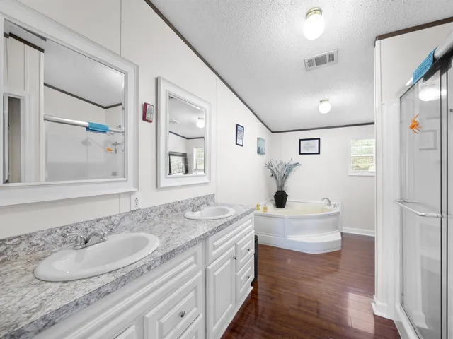 a bathroom with a sink double vanity granite tub and shower