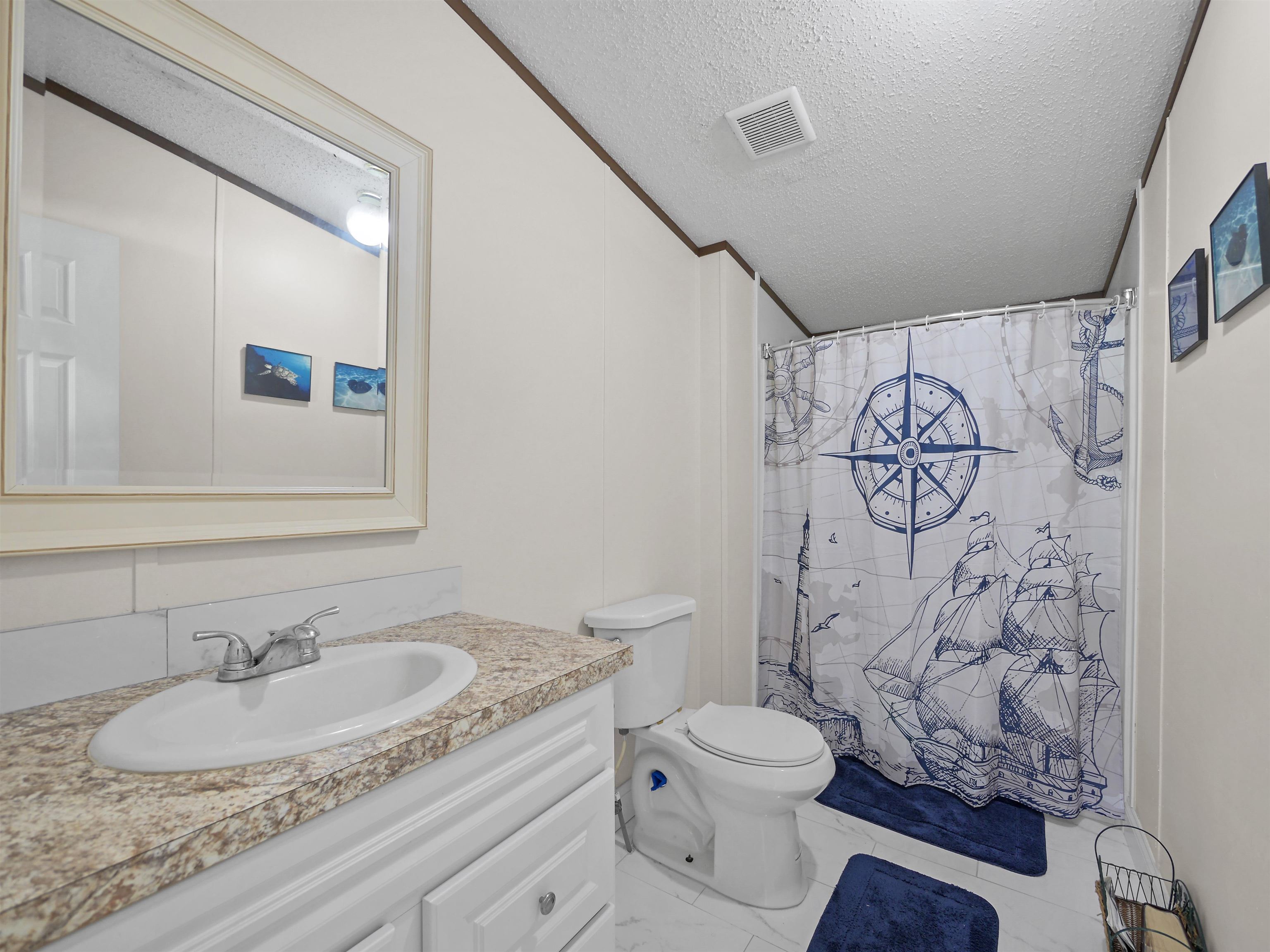 2961 Race Track Road St. Augustine, FL 32084 - Photo 22 of 42 a bathroom with a granite countertop sink a toilet and a mirror