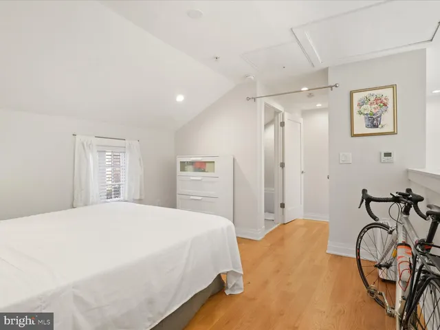 a spacious bedroom with a bed and table chair