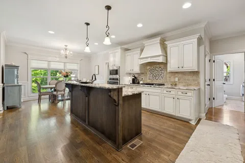 a kitchen with a sink stainless steel appliances and white cabinets