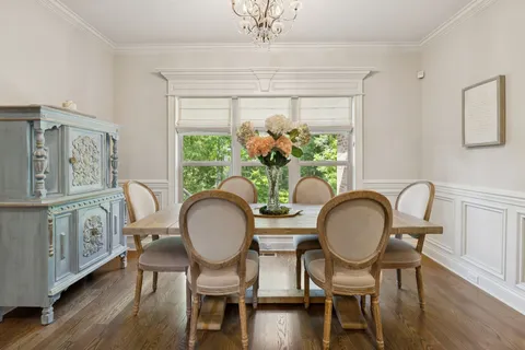a dining room with furniture a chandelier and wooden floor