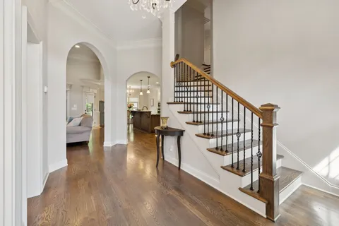 a view of front door with hallway and wooden floor