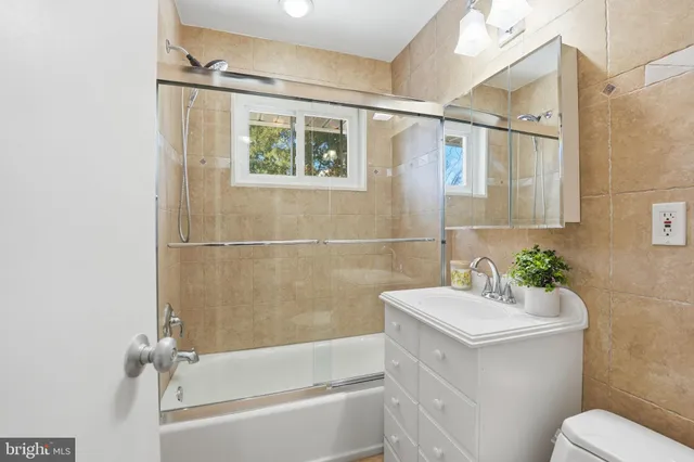 a bathroom with a sink mirror bathtub and toilet