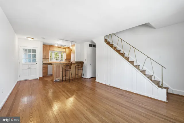 a view of a livingroom with wooden floor and stairs