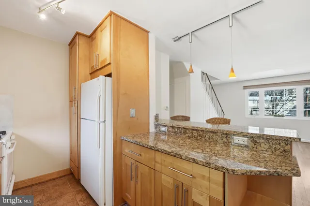 a bathroom with a granite countertop sink and a shower