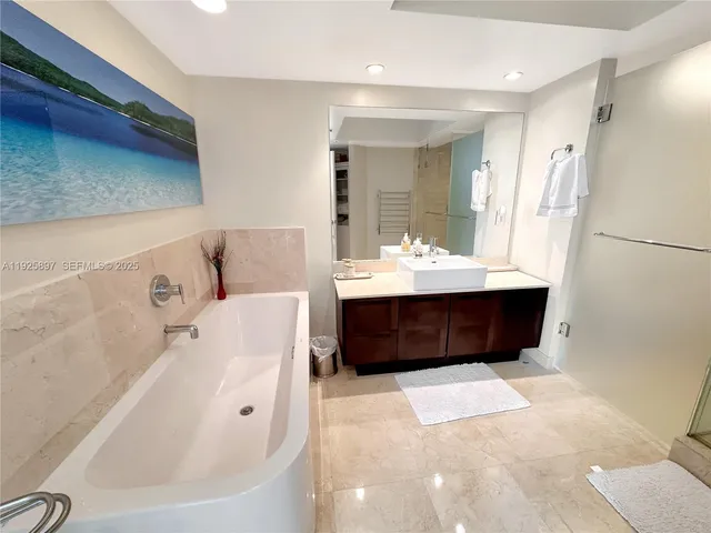 a bathroom with a tub a sink and a mirror