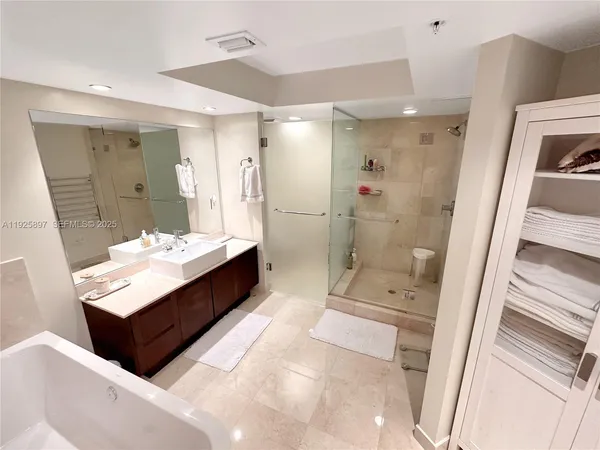 a bathroom with a double vanity sink toilet mirror and bathtub
