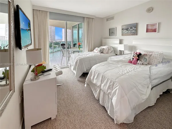 a bedroom with a bed and flat screen tv