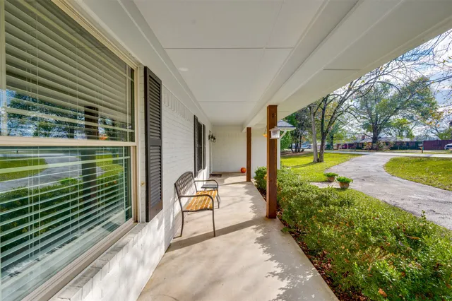 a front view of a house with a garden and trees