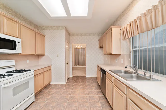 a kitchen with granite countertop a sink stove and cabinets