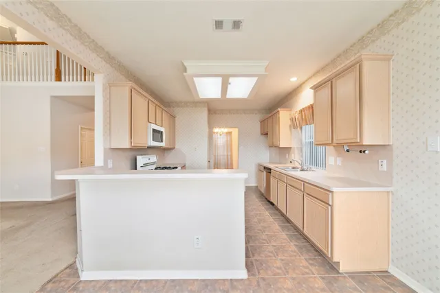a large kitchen with stainless steel appliances lots of counter space and a sink