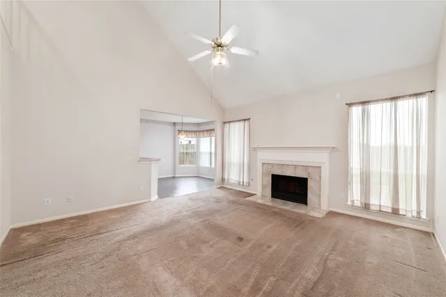 an empty room with windows and fireplace